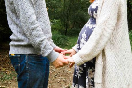 couple baby bump session with couple holding hands