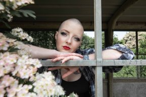 Bald model framed by wooden windows and blossoms