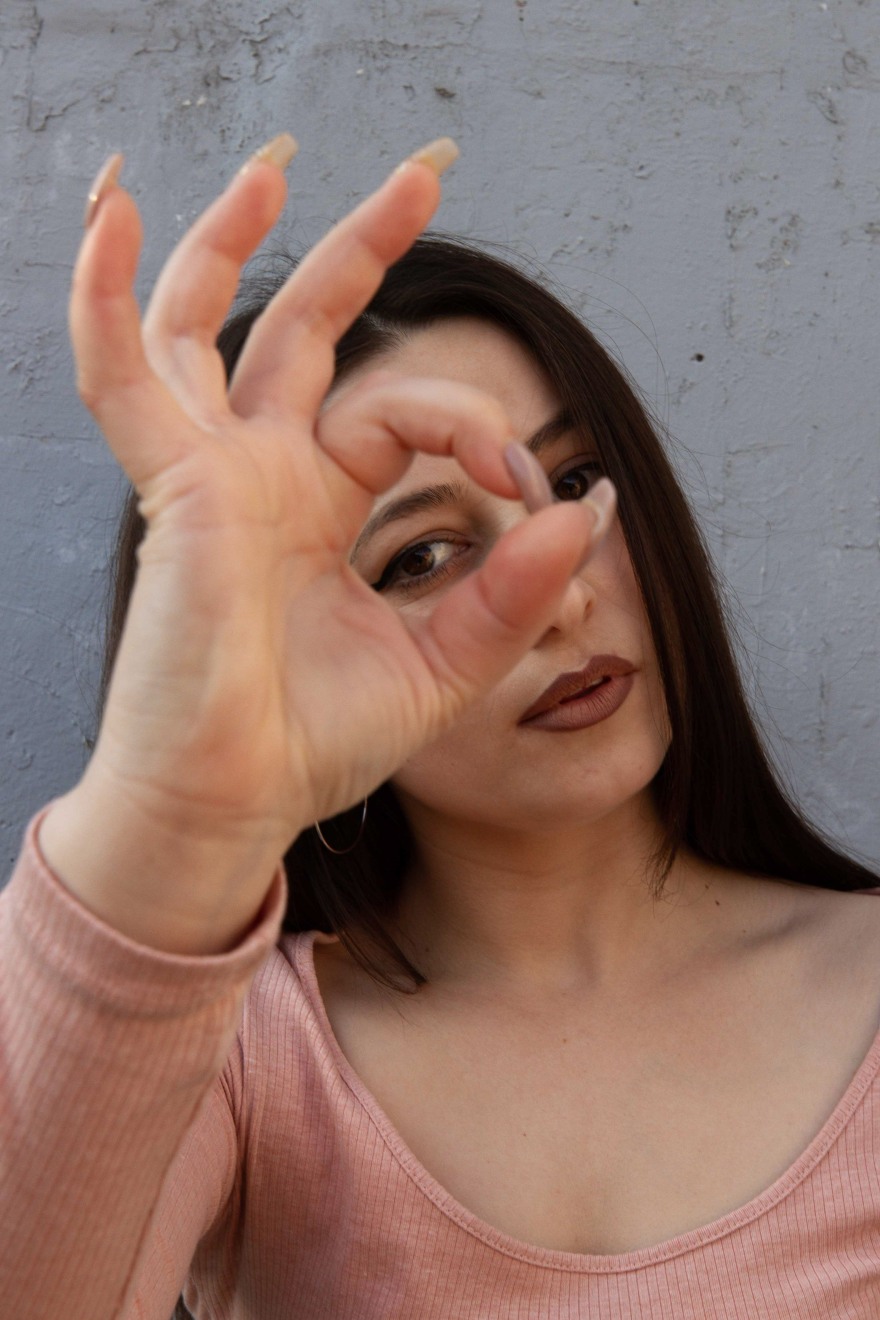 Portrait of model framing her eye with her finger